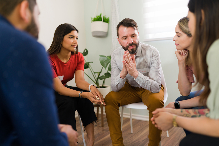 Een begeleider in gesprek met een groep volwassenen